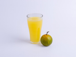 A glass of fresh orange juice next to a whole orange fruit on a white background. Concepts for healthy drink, citrus, vitamin C, beverage, refreshment, fresh, isolated, organic.
