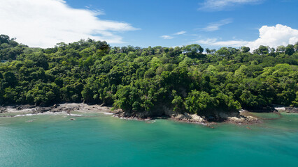 Obraz premium Coastline landscape at Biesanz Beach with turquoise waters and lush green nature on a sunny morning in Costa Rica.