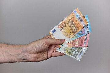 Hand Holding Euro Banknotes on Neutral Background