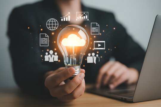 Illuminating Ideas: A visionary professional holds a glowing lightbulb, symbolizing innovative cloud computing, with holographic icons representing various data-driven applications and services.