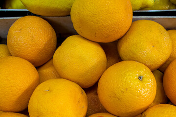 Many orange oranges. Oranges in a box. Sale of oranges at the market and store. Background. Top view. Conservation for the winter. Vegetarianism.