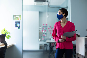 Fototapeta premium Office workspace is featuring white desk and chair near glass partition with colorful sticky notes