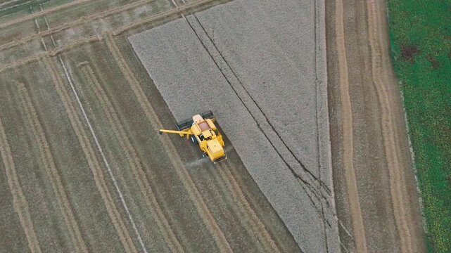 Aerial crop duster plane traversing expansive farmland in dramatic bird?seye view