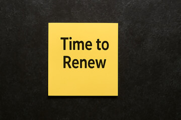 Time to renew reminder note on yellow sticky paper, black textured background, renewal deadline concept, contract subscription update, business schedule planning, important task alert, service extensi