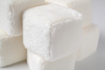 Plush cube blocks arranged stacked structure close up shot highlighting soft corner detailing pure white isolated background