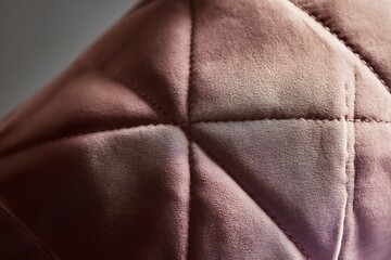 Plush diamond shaped cushion soft velvet fabric close up showing stitching line warm studio lighting