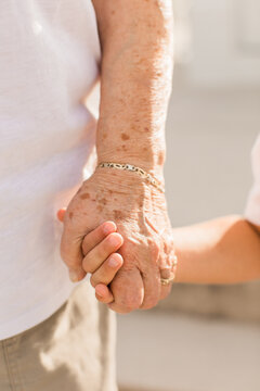 Closeup of Grandma holding hands with her grandchild