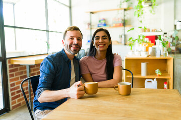 Smiling couple enjoying coffee together in cozy cafe