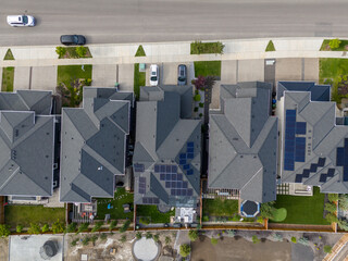Looking down on new suburban homes with solar panels installed on the roof.