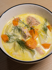 A bowl of salmon and vegetable soup.