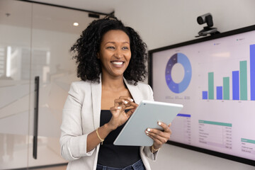 Data analyst at work. Successful smiling young Black businesswoman pose in innovative office use...