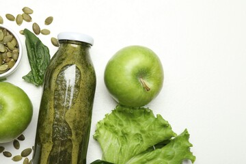 Superfood. Tasty smoothie in glass bottle and ingredients on white table, flat lay. Space for text