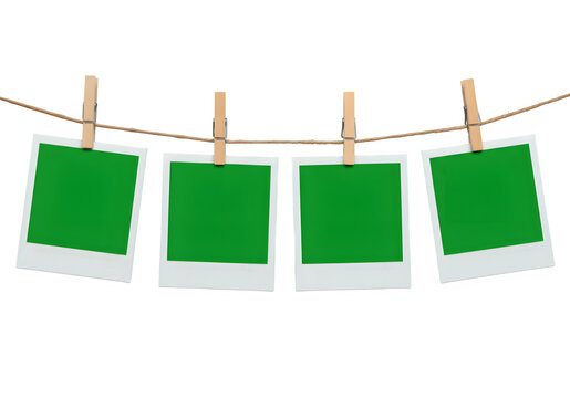 A row of four Chroma key Green format Polaroid frames pinned on a rope with clothespins, , isolated on white or transparent background. PNG
