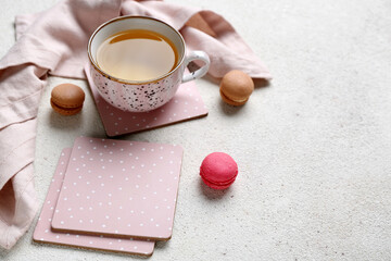 Drink coasters with cup of tea and macaroons on white table