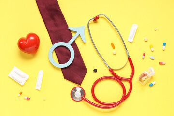 Stethoscope, tie, heart, pills and male sign on yellow background. Prostate cancer awareness