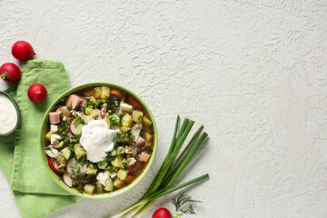 Bowl with tasty okroshka and ingredients on light background