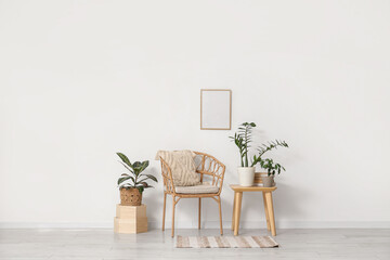 Interior of light room with armchair, table and green plants