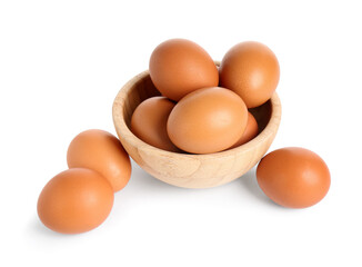 Wooden bowl with brown chicken eggs on white background