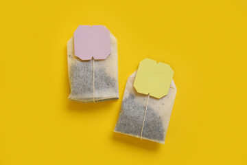 Composition with tea bags on yellow background, closeup
