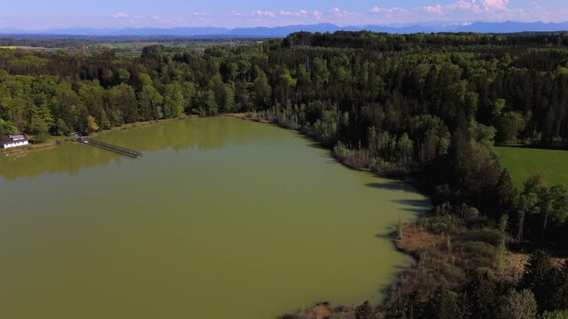 Aerial view of Esssee, a shrinking glacial lake near the Max Planck Institute for Biological Intelligence, in Seewiesen, Gemeinde Poecking, Landkreis Starnberg, Upper Bavaria, Germany in spring