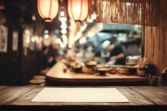 Empty wooden tabletop with blank paper sheet in cozy Japanese izakaya setting, warm lantern lighting and blurred chefs in background, ideal for traditional restaurant mockup or menu concept