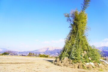 屋外に作られた正月飾りや書初めを燃やすための竹で作られたどんどやの大きな櫓、日本の正月行事の準備