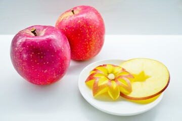 白背景に花の形に飾り切りされた林檎と輪切りで星形に型抜きされた可愛らしい林檎