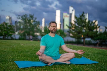  Hispanic Man meditating in lotus pose in grass outdoors. Sportsman doing yoga asanas meditating in city park. Athletic male meditating, relaxation, concept of healthy lifestyle. Outdoor meditating. © Volodymyr