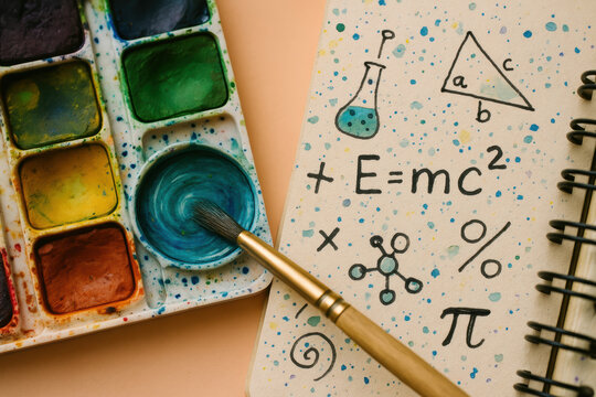 Creative intersection of art and science, colorful watercolor palette and math chemistry doodles on notebook page