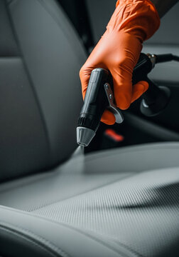 Professional car seat cleaning with spray and brush