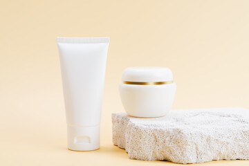 Cosmetic bottles on a stone podium, package for mock up on a beige background. The concept of natural beauty products.