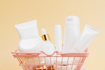 Cosmetic bottles with blank labels in a shopping basket, placed against a beige background for mockup purposes.