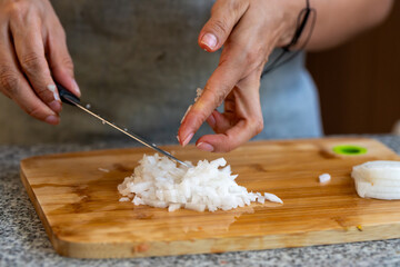Cortando y picando vegetales y legumbres en casa sobre tabla de corte y cuchillo de cheff