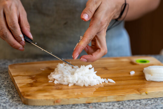 Cortando y picando vegetales y legumbres en casa sobre tabla de corte y cuchillo de cheff