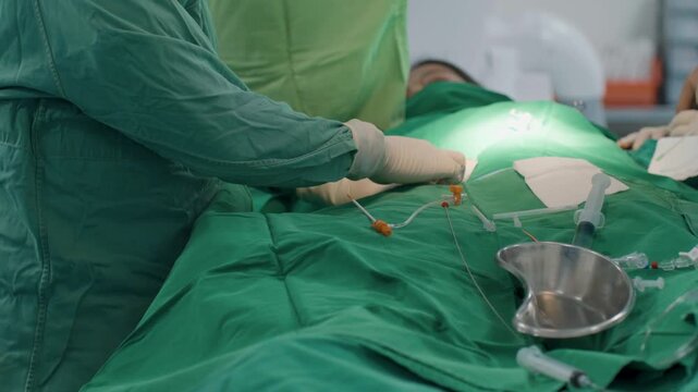 Surgeon's gloved hands perform heart surgery under sterile conditions, with careful precision and focused lighting in the operating room.