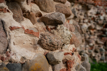 Close-up of ancient stone and brick wall structure from historic ruins, detailed medieval masonry texture showing aged materials, ideal for architecture, history or restoration themes