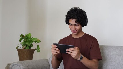 Young indian teenager boy playing online games on smart phone. Wireless technology. Mobile phone addiction. Entertainment. 5G Network. High speed internet. 4k