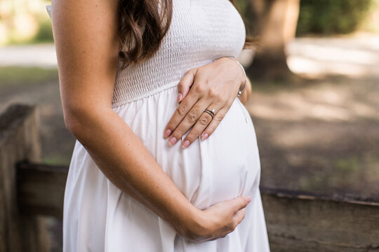 a woman holding her pregnant belly in anticipation of meeting her baby soon