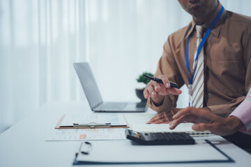 Financial Collaboration: A duo of focused professionals collaborates closely on a financial project, the details of which are meticulously recorded.