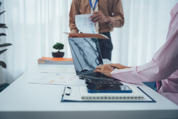 Focused Teamwork in Office: Two colleagues collaborate in a bright and modern office environment, reviewing documents and engaging in a data-driven discussion.  