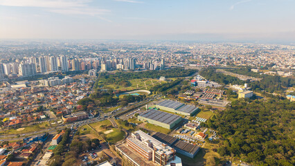 High aerial shot of Curitiba showing Botanical Garden, city skyline, neighborhoods, and surrounding forest.