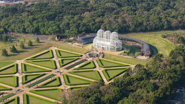 Drone perspective of Curitiba&rsquo;s iconic greenhouse and symmetrical gardens framed by surrounding forest.