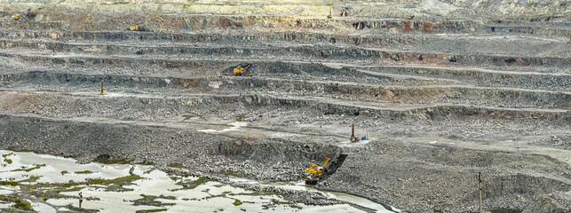 extraction of granite in open cast mine with mining machinery. panoramic view of granite quarry.