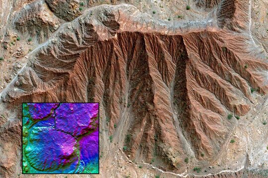 High-angle view of eroded, colorful mountain range.  Detailed topographical map inset