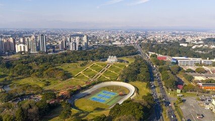 Aerial view of Curitiba's Botanical Garden and city skyline on a clear day.