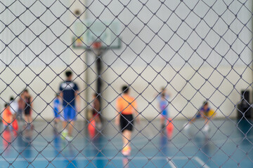 blur basketball court by rope mesh net fence focus with many youth children or kid learning training dribbling shooting ball to playing basketball with coach and basketball hoop for sport exercise