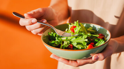 Healthy Salad Bowl - Fresh Ingredients & Nutritious Meal, Close-up shot of hands holding a vibrant green bowl filled with a fresh and colorful salad. The salad contains a mix of crisp lettuce.