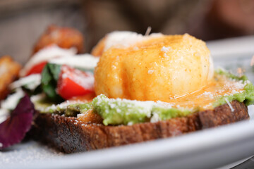 Delicious brunch with poached egg and avocado toast