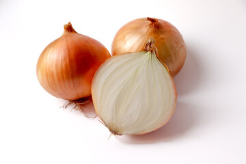 Whole onion with unpeeled and half an onion cut in half on a white background