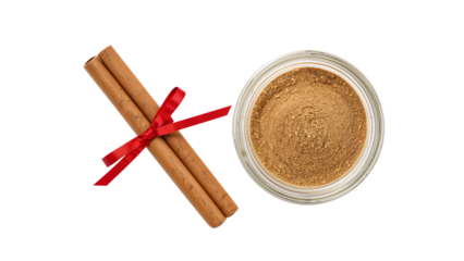 Cinnamon sticks with red ribbon and ground cinnamon in glass jar on the transparent background, aromatic spice for baking, cooking, holiday decor